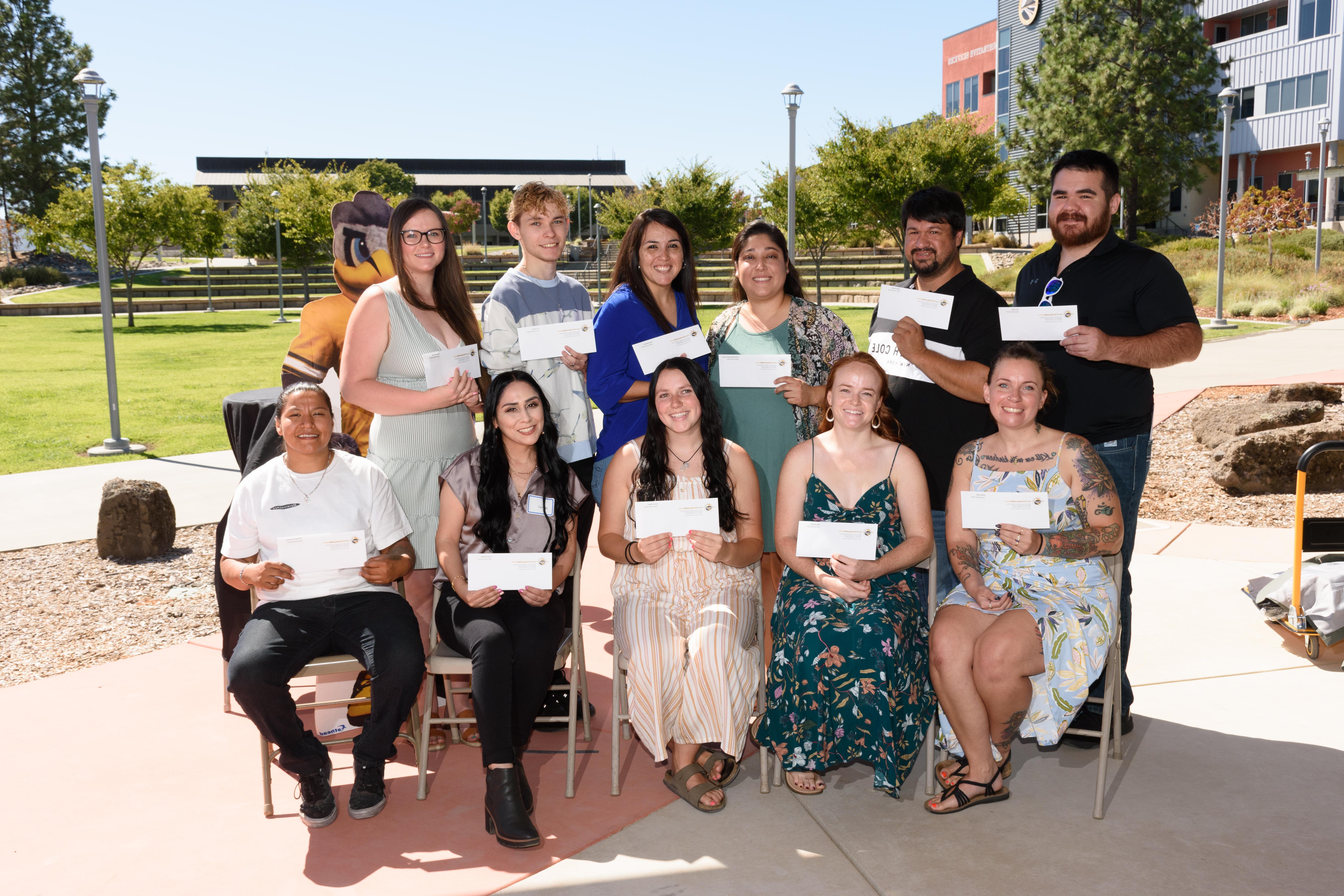 A group of students pose together with their scholarship checks.